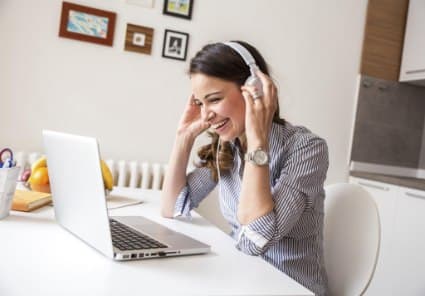 Woman with headphone looking at laptop