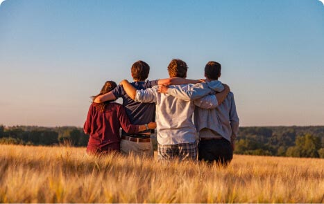 gruppo di persone che si abbracciano in un campo